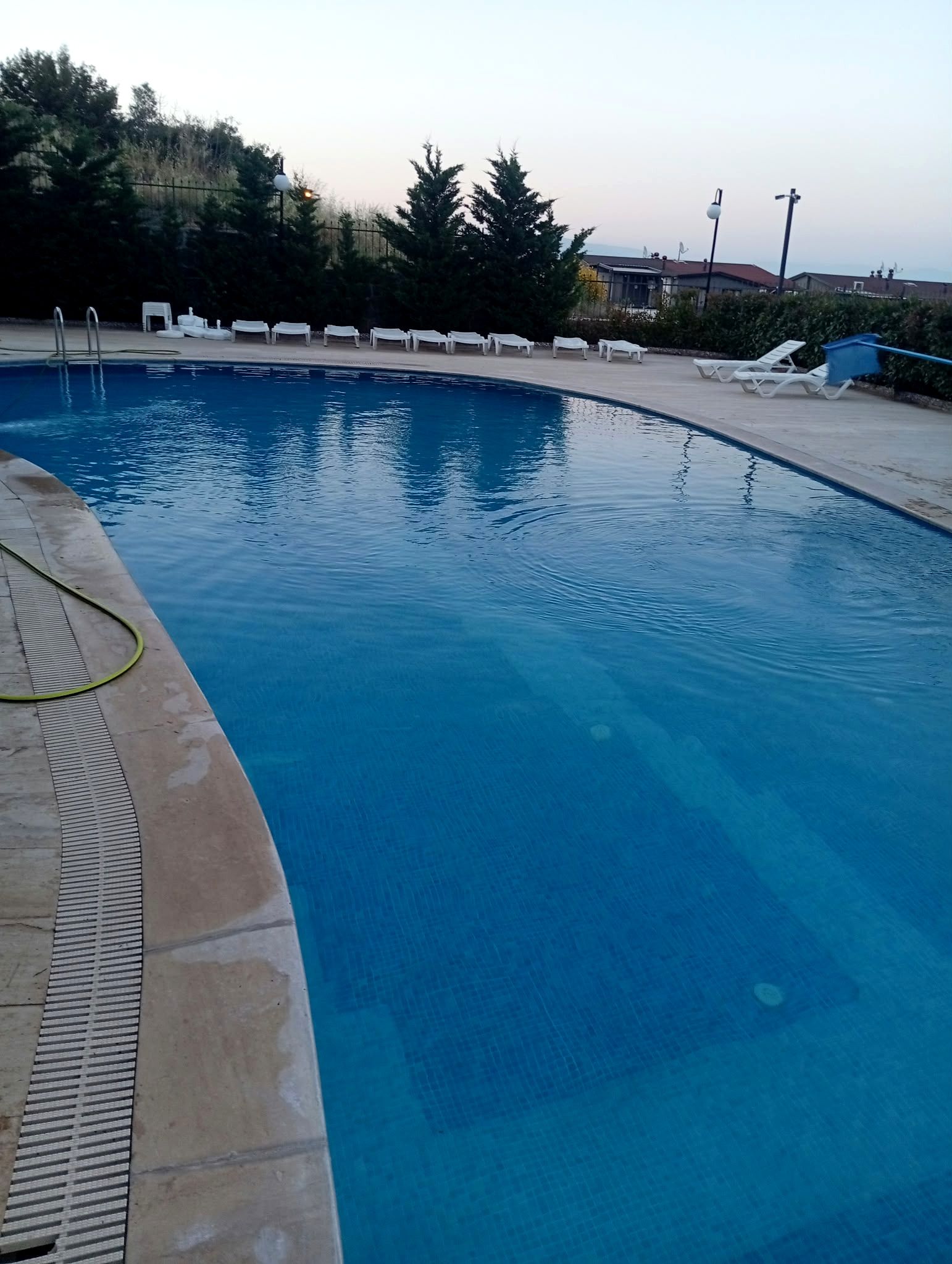 Gün batımında havuz kenarı ve temiz havuz suyu